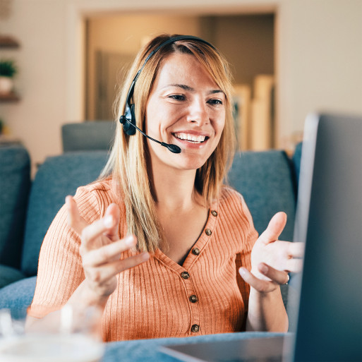 Person mit Headset lächelt während eines Videocalls